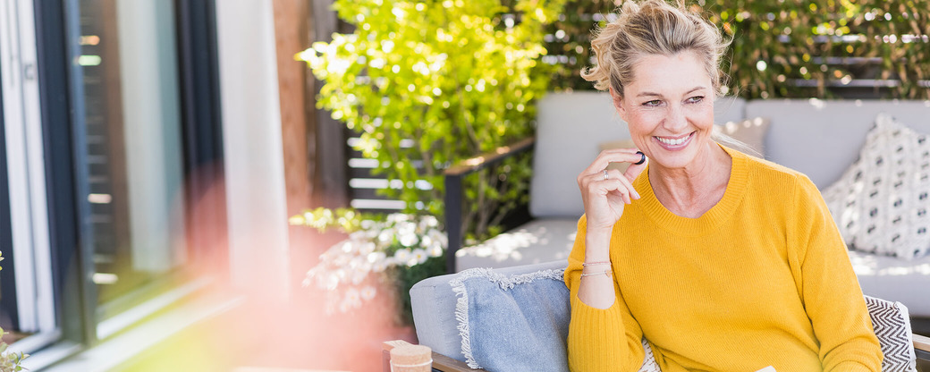 Frau isst Heidelbeeren auf Terrasse